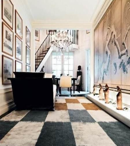 Ở một góc khác trong phòng khách, toàn bộ không gian được thiết kế theo phong cách hiện đại và sang trọng. Tường hai bên được trang trí bằng những bức tranh của các họa sĩ nổi tiếng. Các bức tượng gốm với hình hài phụ nữ cổ đại tô điểm phía dưới tạo cảm giác nghệ thuật hoài cổ. Ghế ngồi toàn màu đen và trắng mang đến không gian quý phái. Đèn chùm pha lê trên trần nhà toát lên sự sang trọng quý phái.