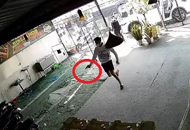 Thanh niên cầm vật giống súng bắn vào bên trong tiệm bida. Ảnh: Cắt từ clip. Thanh niên cầm vật giống súng bắn vào bên trong tiệm bida. Ảnh: Cắt từ clip.