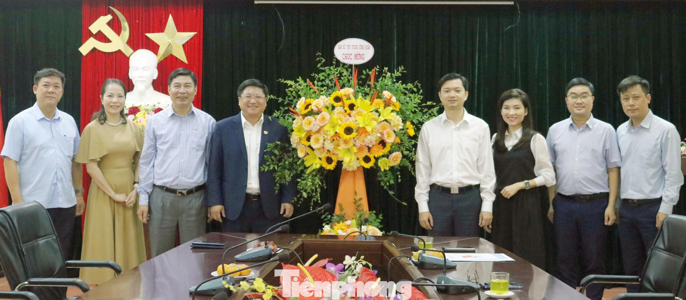 Anh Nguyễn Minh Triết (thứ tư từ phải sang) tặng lẵng hoa chúc mừng 20/11 Học viện Thanh thiếu niên Việt Nam. Ảnh: Bảo Anh