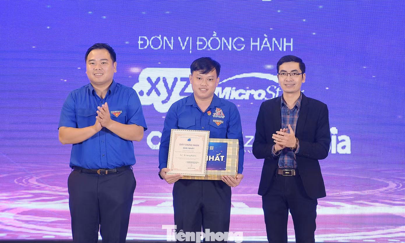 Anh Nguyễn Xuân Hiếu (ngoài cùng bên trái), anh Nguyễn Sỹ Hà - Giám đốc chi nhánh Công ty CP Mắt Bão trao giải Nhất cuộc thi thí sinh Lê Trung Kiên. Ảnh: Xuân Tùng