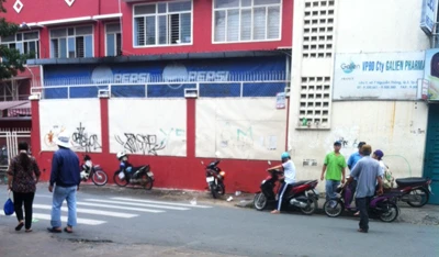 Một “cò” bắt bệnh vào phòng khám tư và một nhóm “cò” khác đang canh mồi trước cổng BV Da liễu TPHCM. Ảnh: L.N 