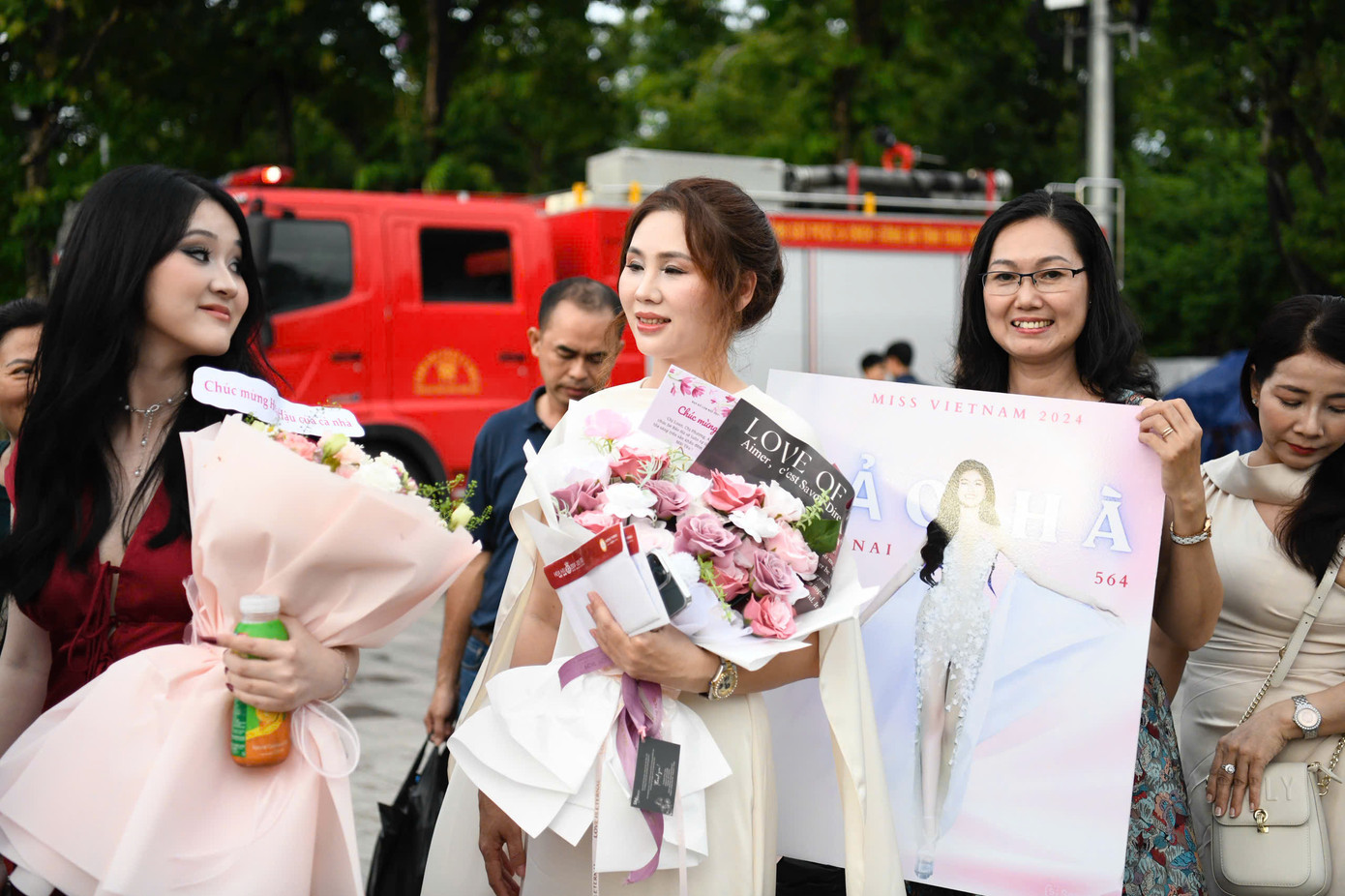 Mọi người ăn diện, mang theo hoa tươi, áp phích để cổ vũ tinh thần cho thí sinh.