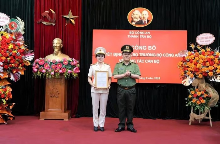 Thiếu tướng Bùi Quang Thanh, Ủy viên Đảng ủy Công an Trung ương, Bí thư Đảng ủy, Chánh Thanh tra Bộ trao quyết định cho Đại tá Phan Thị Loan. Ảnh: Congly.vn.