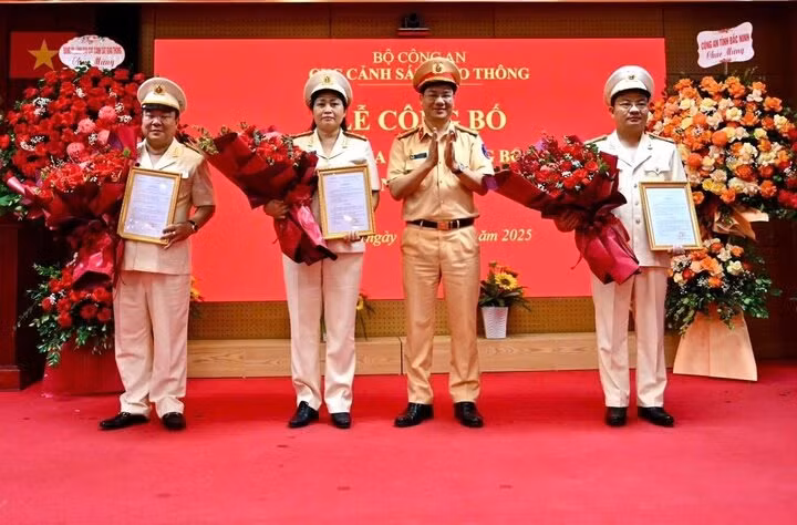 Đại tá Đỗ Thanh Bình, Cục trưởng Cục CSGT, trao quyết định và tặng hoa chúc mừng 3 tân Phó Cục trưởng. Ảnh: Cục CSGT.