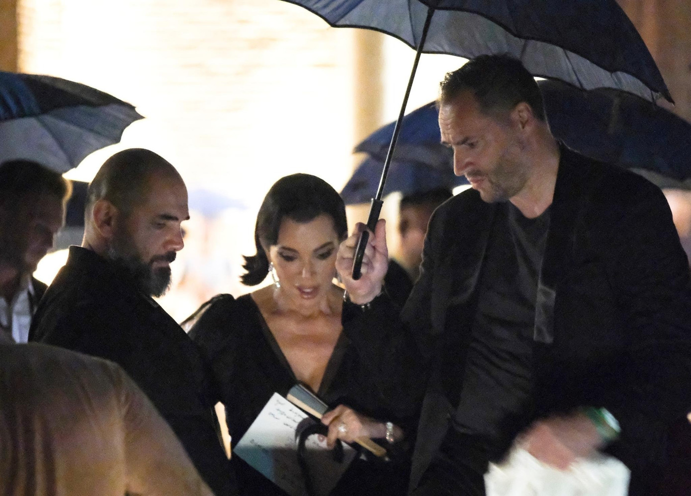 Kris Jenner lộ vẻ mặt lo lắng. Bà được nhân viên giúp đỡ rời khỏi nhà hàng trong cơn mưa lớn. Ảnh: BackGird.