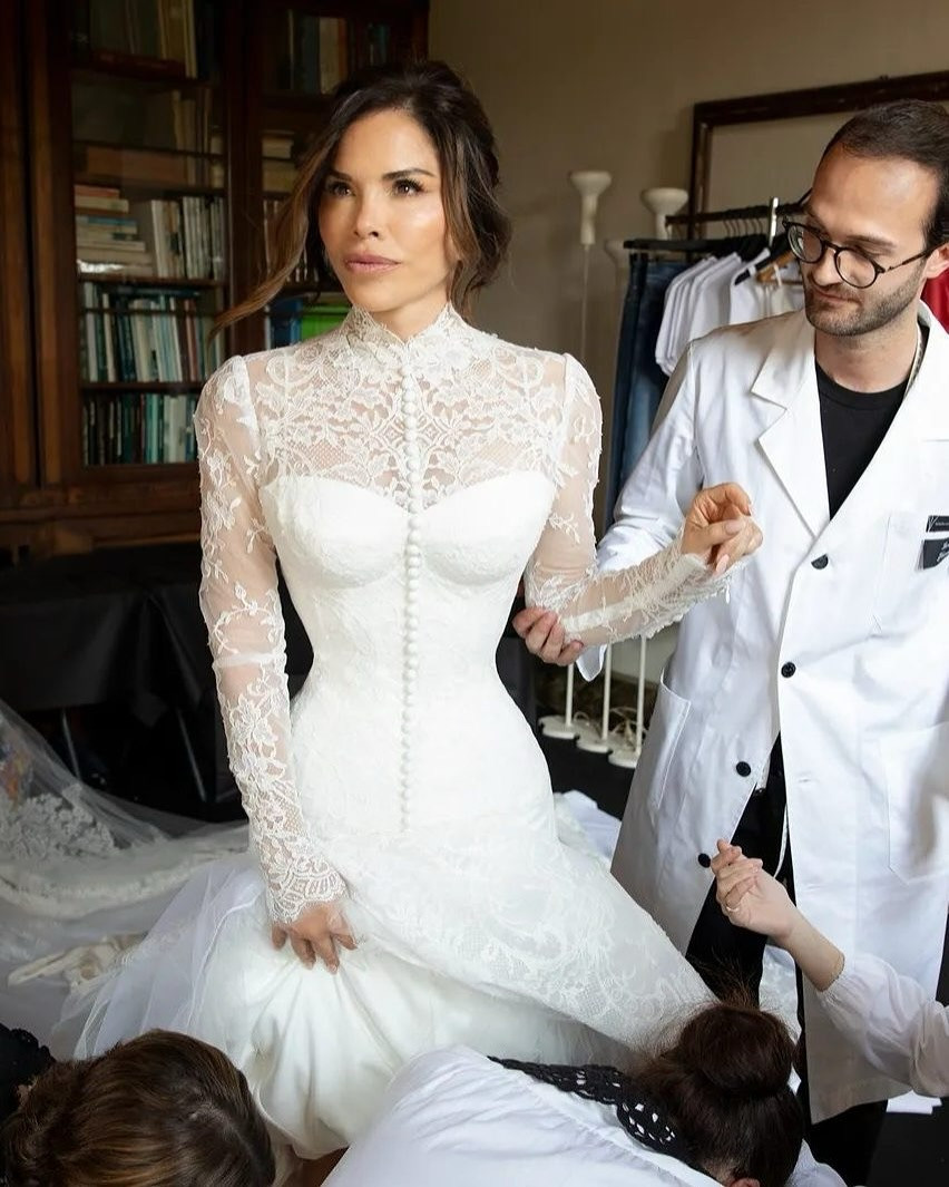 Lauren Sánchez cho biết trang phục lấy cảm hứng từ váy cưới ren cổ cao mà Sophia Loren khi kết hôn trong bộ phim Houseboat năm 1958. “Ý tưởng chuyển từ ’Tôi muốn chiếc váy hiện đại, gợi cảm, đơn giản’ thành ‘Tôi muốn thứ gì đó gợi lên khoảnh khắc’ và nơi tôi đang ở hiện tại. Tôi khác so với 5 năm trước. Tôi nghiên cứu hình ảnh cô dâu vào những năm 1950 và tôi thấy Sophia Loren… Thế là xong. Đó là chiếc váy tôi muốn”, nhà báo 6X nói. Ảnh: Vogue. Lauren Sánchez cho biết trang phục lấy cảm hứng từ váy cưới ren cổ cao mà Sophia Loren khi kết hôn trong bộ phim Houseboat năm 1958. “Ý tưởng chuyển từ ’Tôi muốn chiếc váy hiện đại, gợi cảm, đơn giản’ thành ‘Tôi muốn thứ gì đó gợi lên khoảnh khắc’ và nơi tôi đang ở hiện tại. Tôi khác so với 5 năm trước. Tôi nghiên cứu hình ảnh cô dâu vào những năm 1950 và tôi thấy Sophia Loren… Thế là xong. Đó là chiếc váy tôi muốn”, nhà báo 6X nói. Ảnh: Vogue.