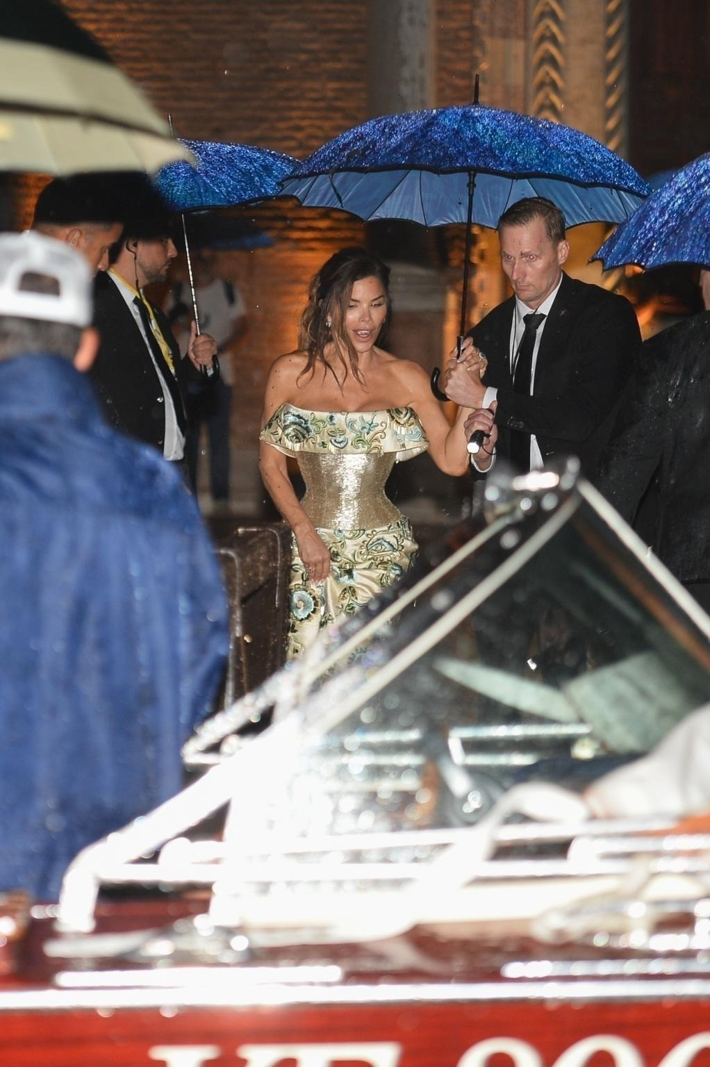 Cô dâu được nhìn thấy ôm váy chạy vội ra taxi nước. Chiếc váy bó sát khiến cô di chuyển bất tiện, cần sự hỗ trợ từ nhân viên nhà hàng. Ảnh: BackGrid.