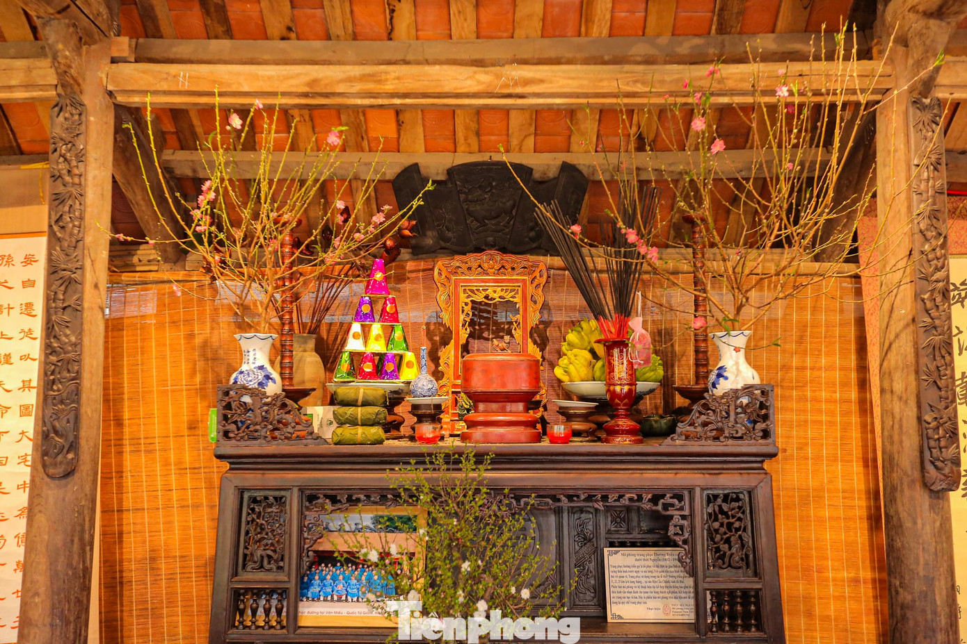 Ban thờ ngày Tết với cành đào, bánh chưng, mâm ngũ quả.