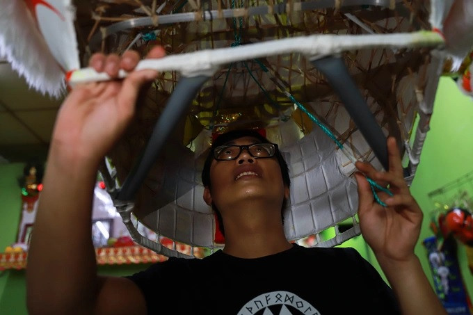 Anh Dương Chí Dũng (32 tuổi) đang kiểm tra những bộ phận bên trong đầu lân, để chắc chắn những chuyển động về tai, mắt, miệng được mượt mà (Ảnh: Nguyễn Vy). Anh Dương Chí Dũng (32 tuổi) đang kiểm tra những bộ phận bên trong đầu lân, để chắc chắn những chuyển động về tai, mắt, miệng được mượt mà (Ảnh: Nguyễn Vy).