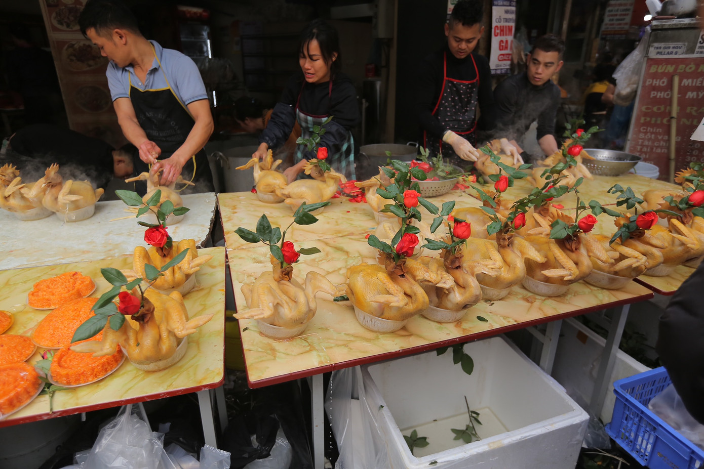 Mặt hàng đặc trưng của khu chợ những ngày cận Tết là gà luộc ngậm hoa hồng. Hai cửa hàng nổi tiếng bán sản phẩm này nằm ở đoạn phố Gia Ngư luôn trong tình trạng tấp nập. Những con gà da vàng óng ả, tạo hình bắt mắt nặng khoảng 2kg được bán với giá từ 600.000 - 800.000 đồng.