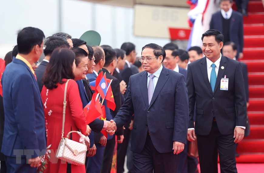 Cán bộ, nhân viên Đại sứ quán và đại diện kiều bào Việt Nam tại Lào đón Thủ tướng Phạm Minh Chính và Đoàn đại biểu cấp cao Việt Nam. (Ảnh: Dương Giang/TTXVN)