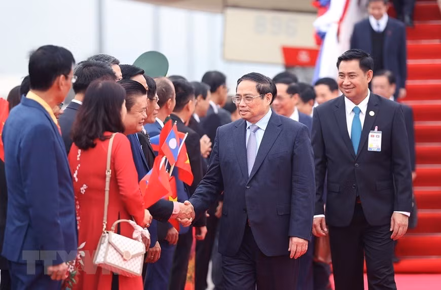 Cán bộ, nhân viên Đại sứ quán và đại diện kiều bào Việt Nam tại Lào đón Thủ tướng Phạm Minh Chính và Đoàn đại biểu cấp cao Việt Nam. (Ảnh: Dương Giang/TTXVN)