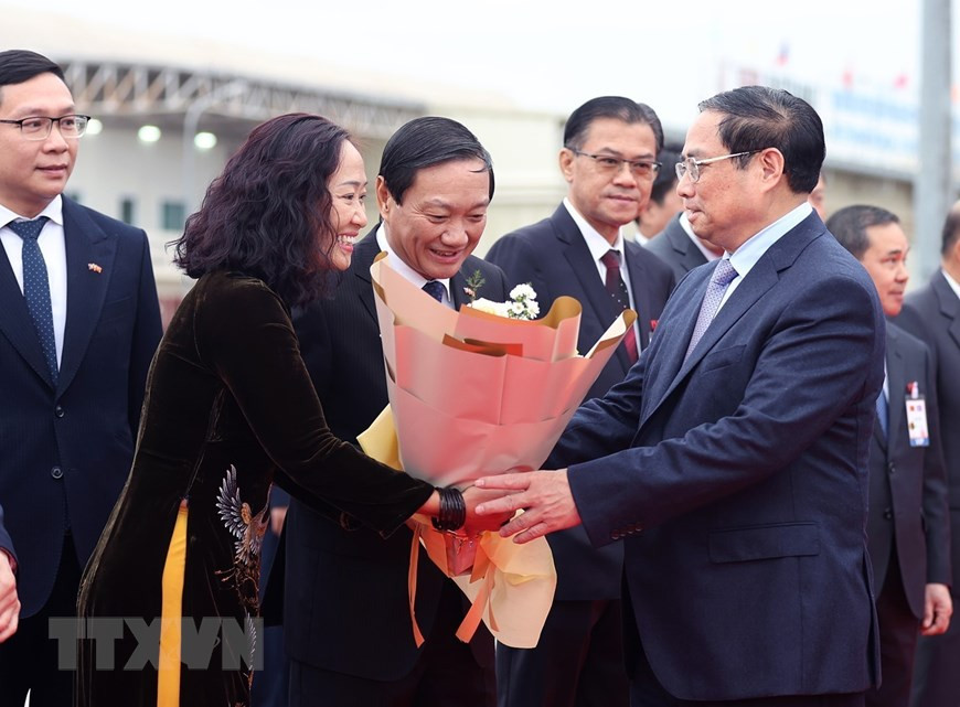 Cán bộ, nhân viên Đại sứ quán và đại diện kiều bào Việt Nam tại Lào đón Thủ tướng Phạm Minh Chính và Đoàn đại biểu cấp cao Việt Nam. (Ảnh: Dương Giang/TTXVN)