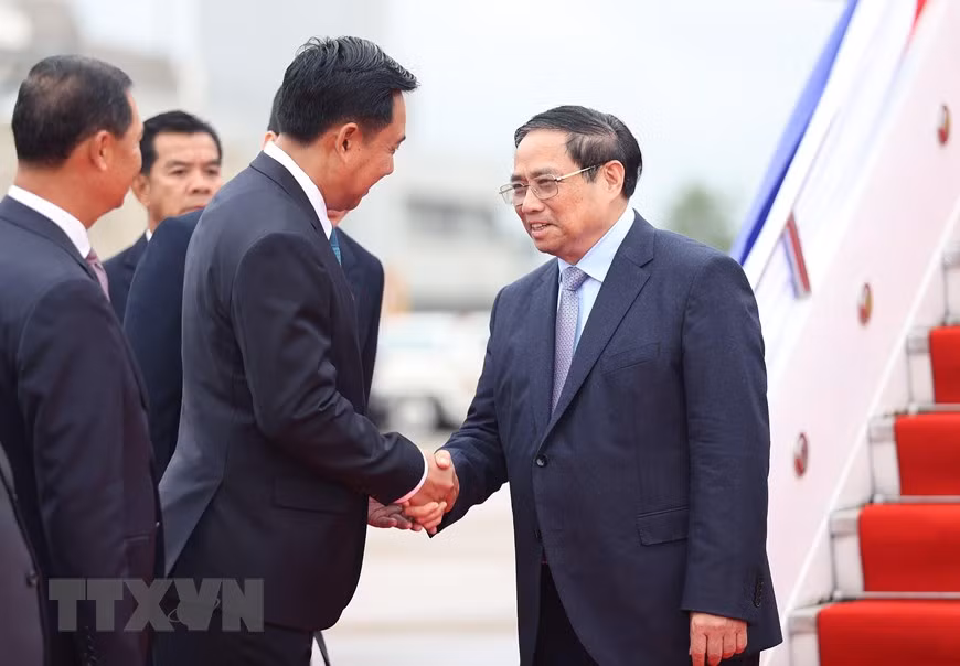 Đại diện Chính phủ Lào đón Thủ tướng Phạm Minh Chính và Đoàn đại biểu cấp cao Việt Nam tại sân bay quốc tế Wattay. (Ảnh: Dương Giang/TTXVN)