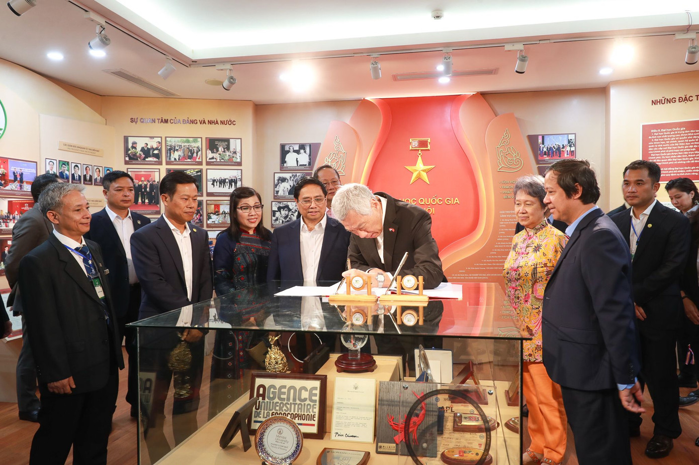 Trước đó, Thủ tướng Phạm Minh Chính, Thủ tướng Lý Hiển Long cùng hai Phu nhân tới thăm phòng truyền thống của ĐH Quốc gia Hà Nội