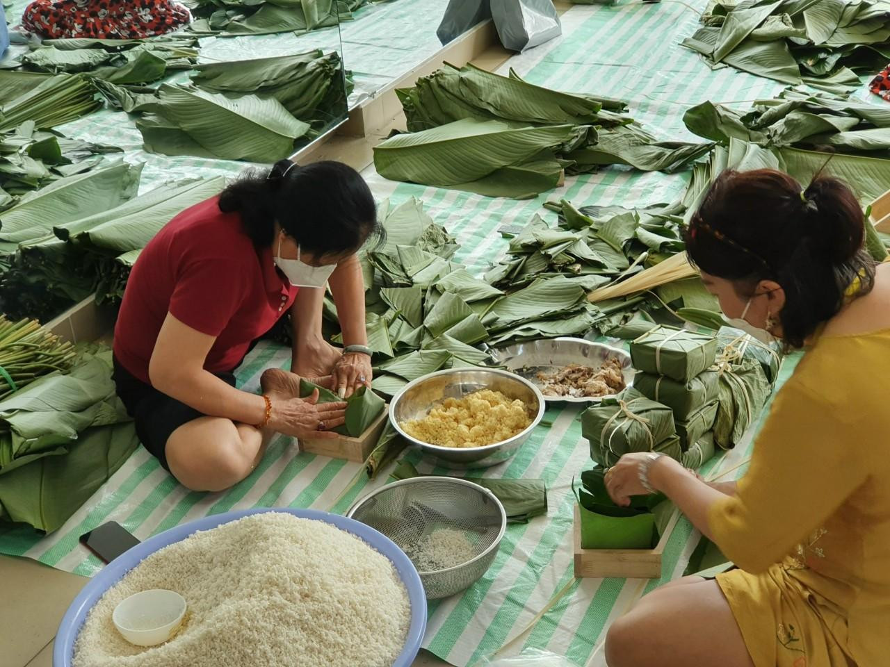 Mọi người cùng nhau gói bánh trong tiếng nói cười rôm rả ngày cuối năm. Ảnh: NVCC