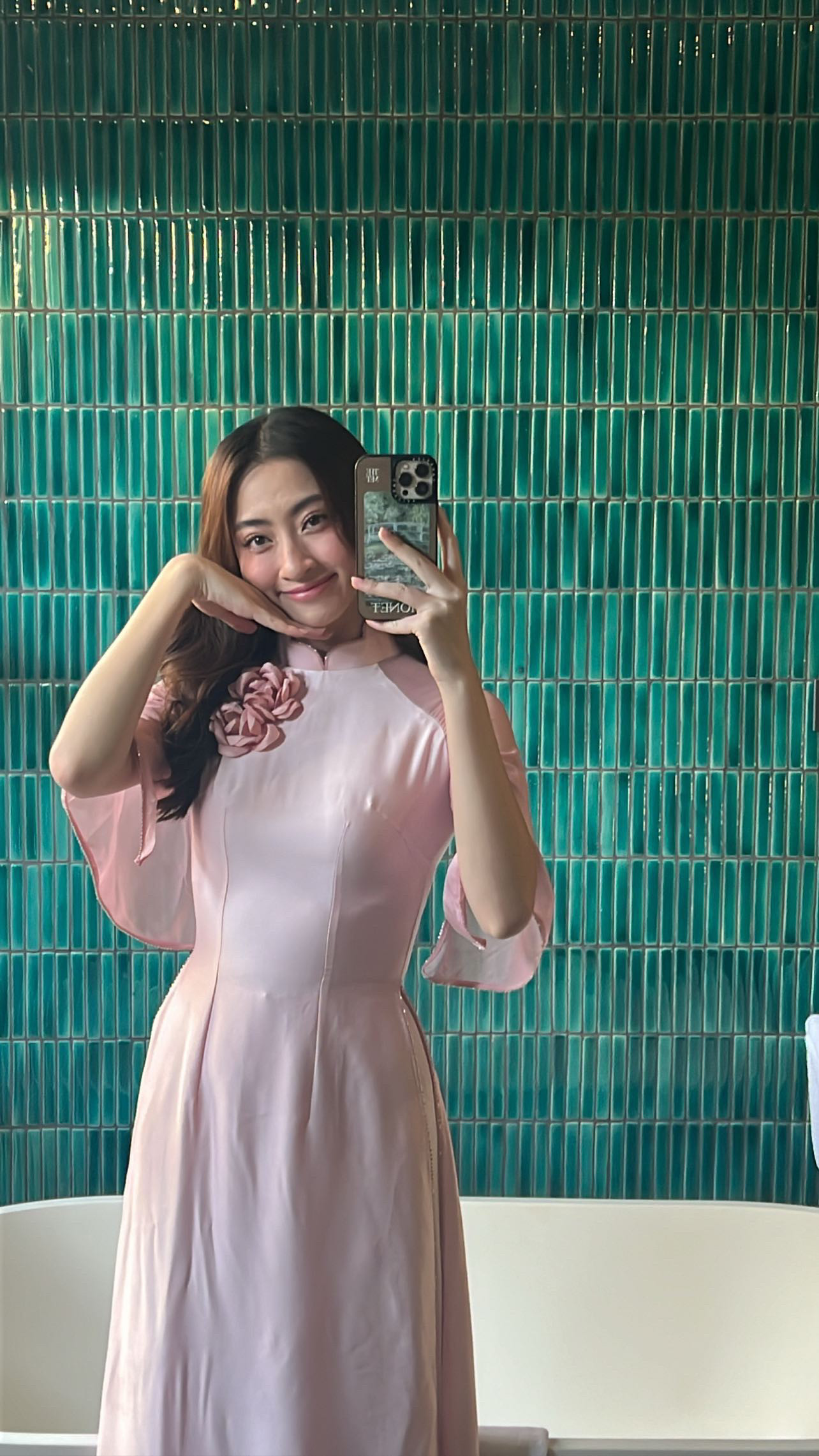 Hoa hậu Lương Thùy Linh chụp ảnh trước giờ làm lễ. Cô dịu dàng, nền nã khi mặc áo dài, khác với nhan sắc cá tính, sắc sảo như thường thấy.