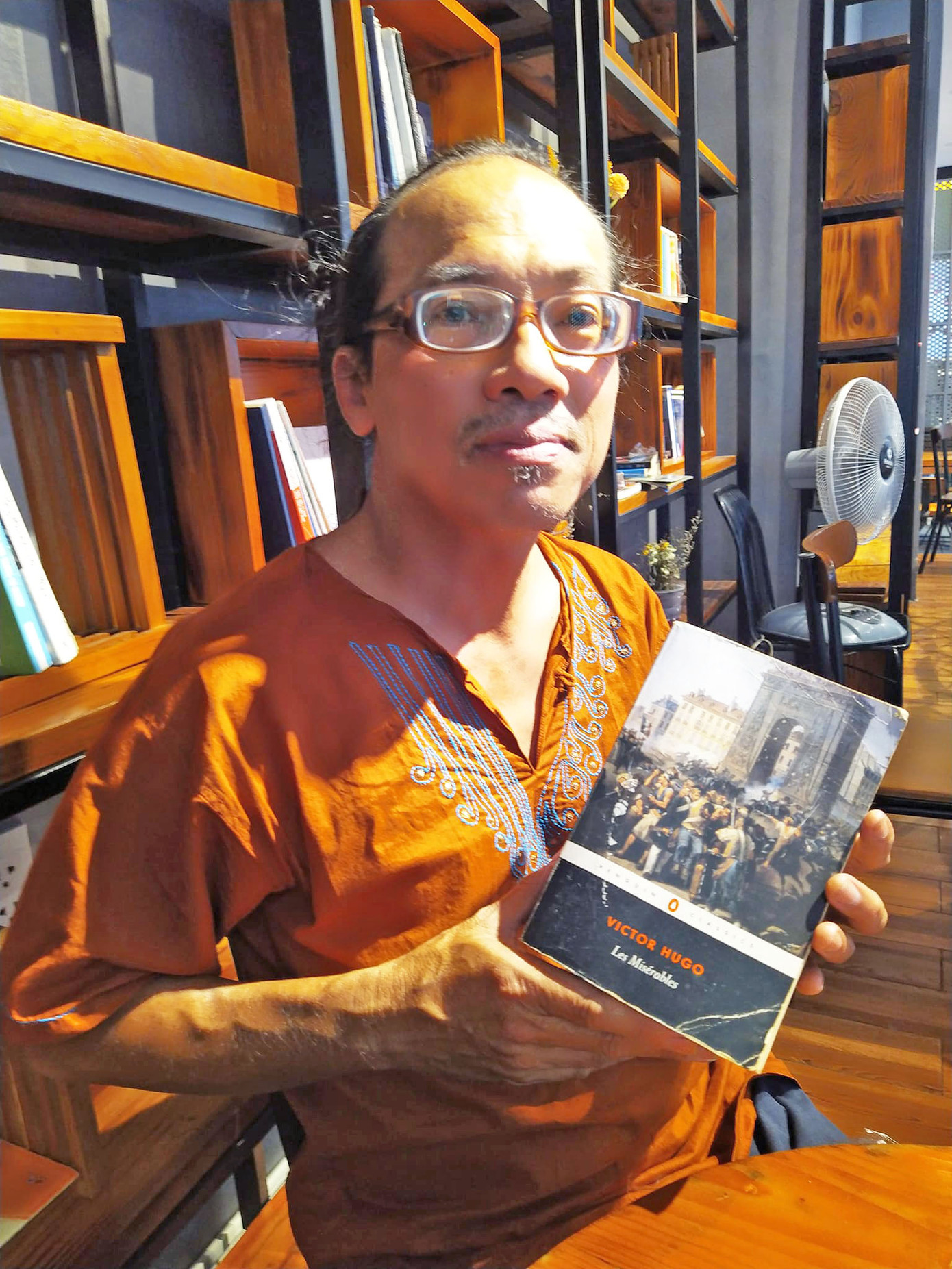 Một dịch giả vui mừng khi nhìn thấy cuốn "Những người khốn khổ" của Victor Hugo bản tiếng Anh tại đường sách Nguyễn Bình