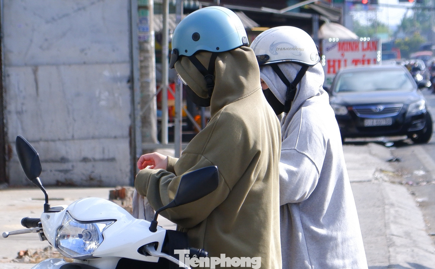 Nắng nóng, người đi đường phải dừng xe để đeo bao tay, che chắn cơ thể.