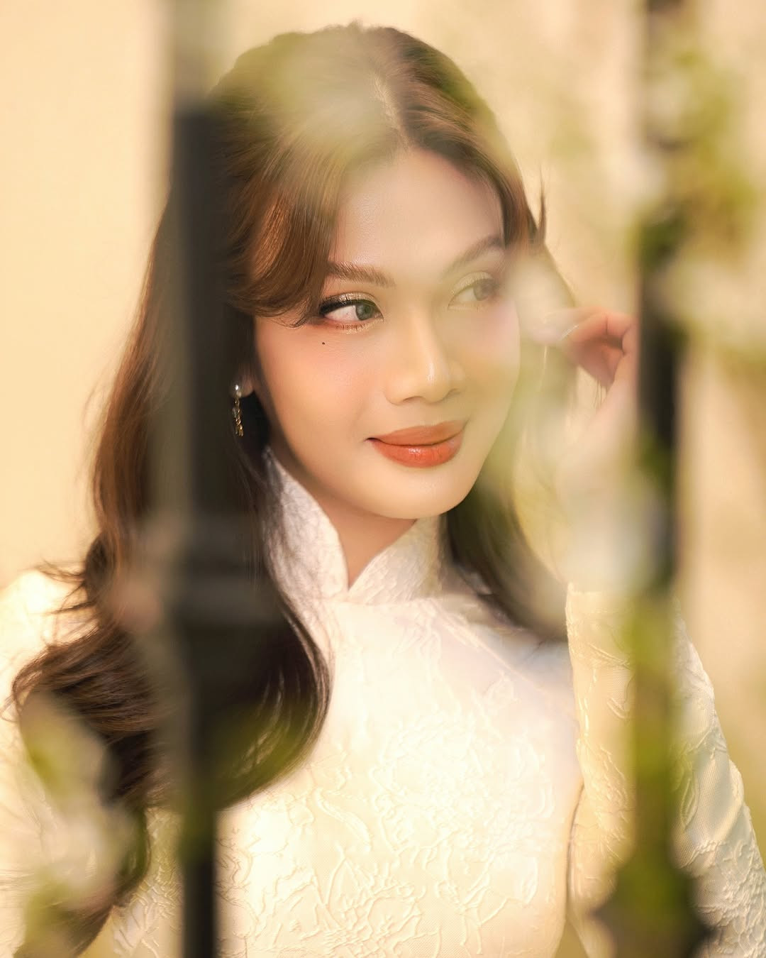 Luna Đào tạo dáng bên cành tuyết mai nở rộ. Nữ ca sĩ chuyển giới thêm phần đằm thắm và nữ tính với tà áo dài truyền thống.