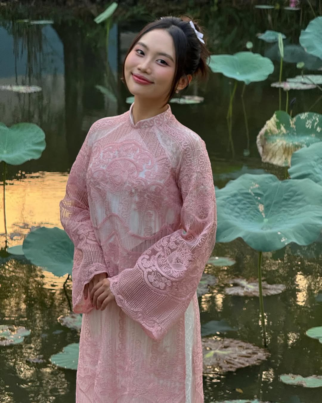 Phương Mỹ Chi thả dáng với áo dài bên hồ sen. Cô được người hâm mộ khen &quot;thắm&quot;.