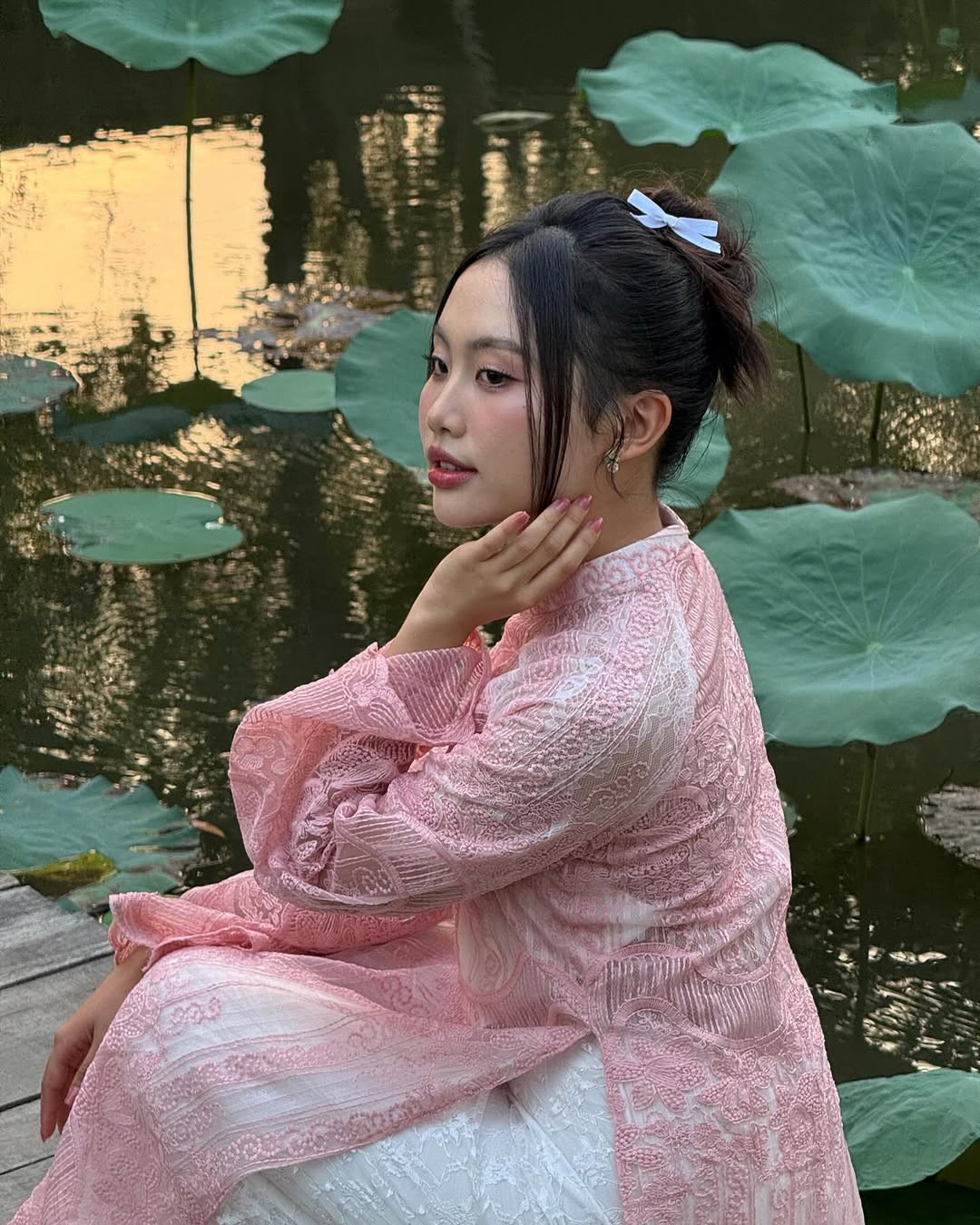 Phương Mỹ Chi thả dáng với áo dài bên hồ sen. Cô được người hâm mộ khen &quot;thắm&quot;.