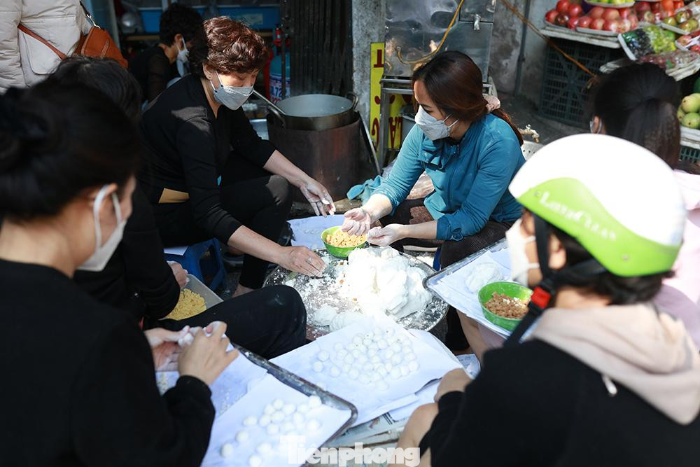 Bên cạnh cửa hàng nhiều người ngồi làm bánh trôi không ngơi tay