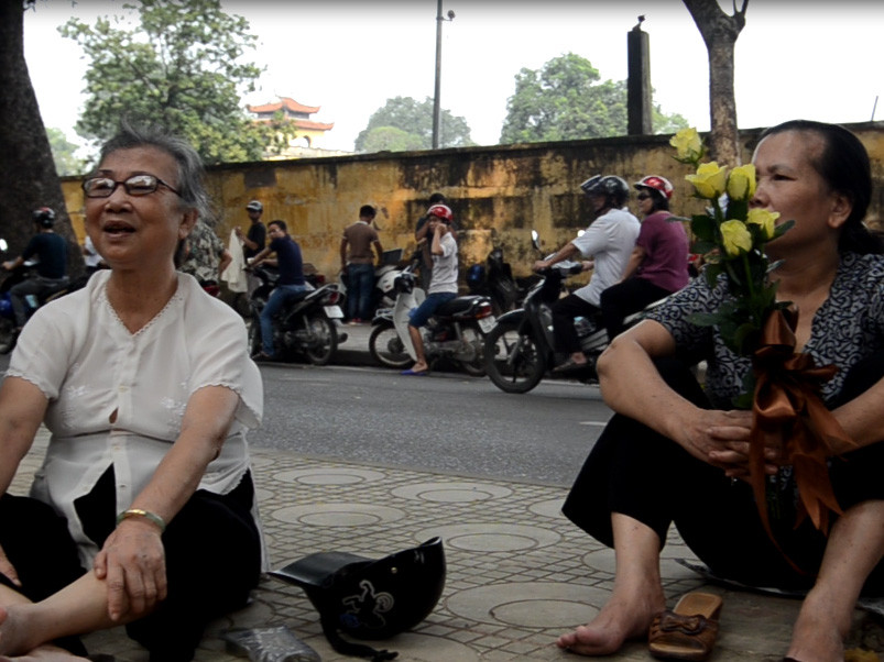 Bác Phạm Thị Bằng (trái) đi xe ôm đến từ 1h chiều đã ngồi trên vỉa hè chờ vào tưởng niệm Đại tướng