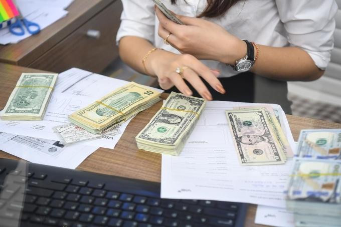 Nhân viên ngân hàng thực hiện giao dịch cho khách hàng. Ảnh: Giang Huy