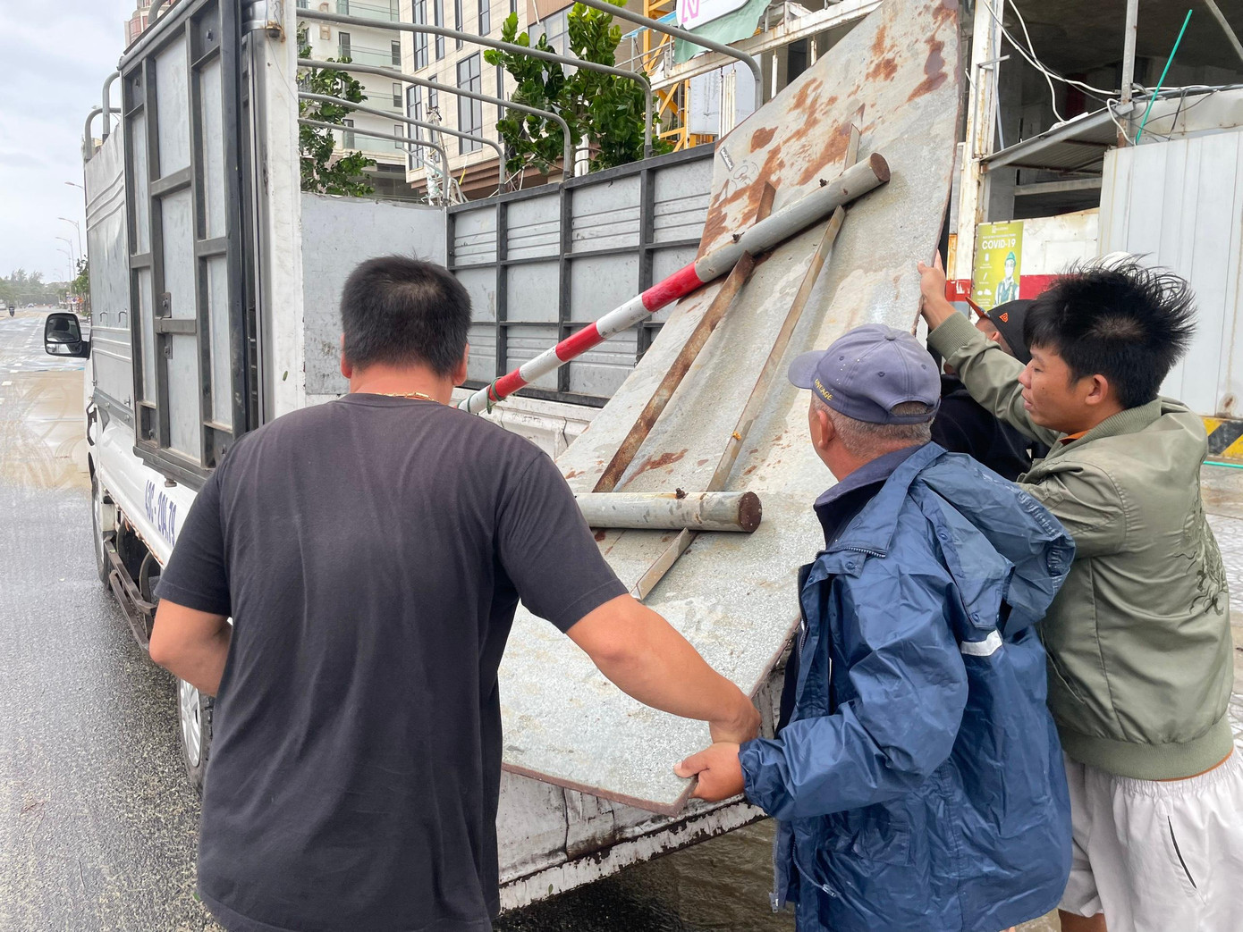 Người dân phối hợp cùng cán bộ địa phương thu dọn biển bảng bị đổ