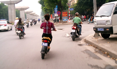 Cô gái đầu trần điều khiển xe đạp điện treo biển 