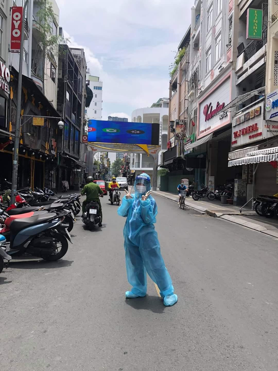 Ngọc Thùy trong trang phục bảo hộ, hỗ trợ các thành viên khác trong đội khử khuẩn tại khu phố Bùi Viện (Q. 1).