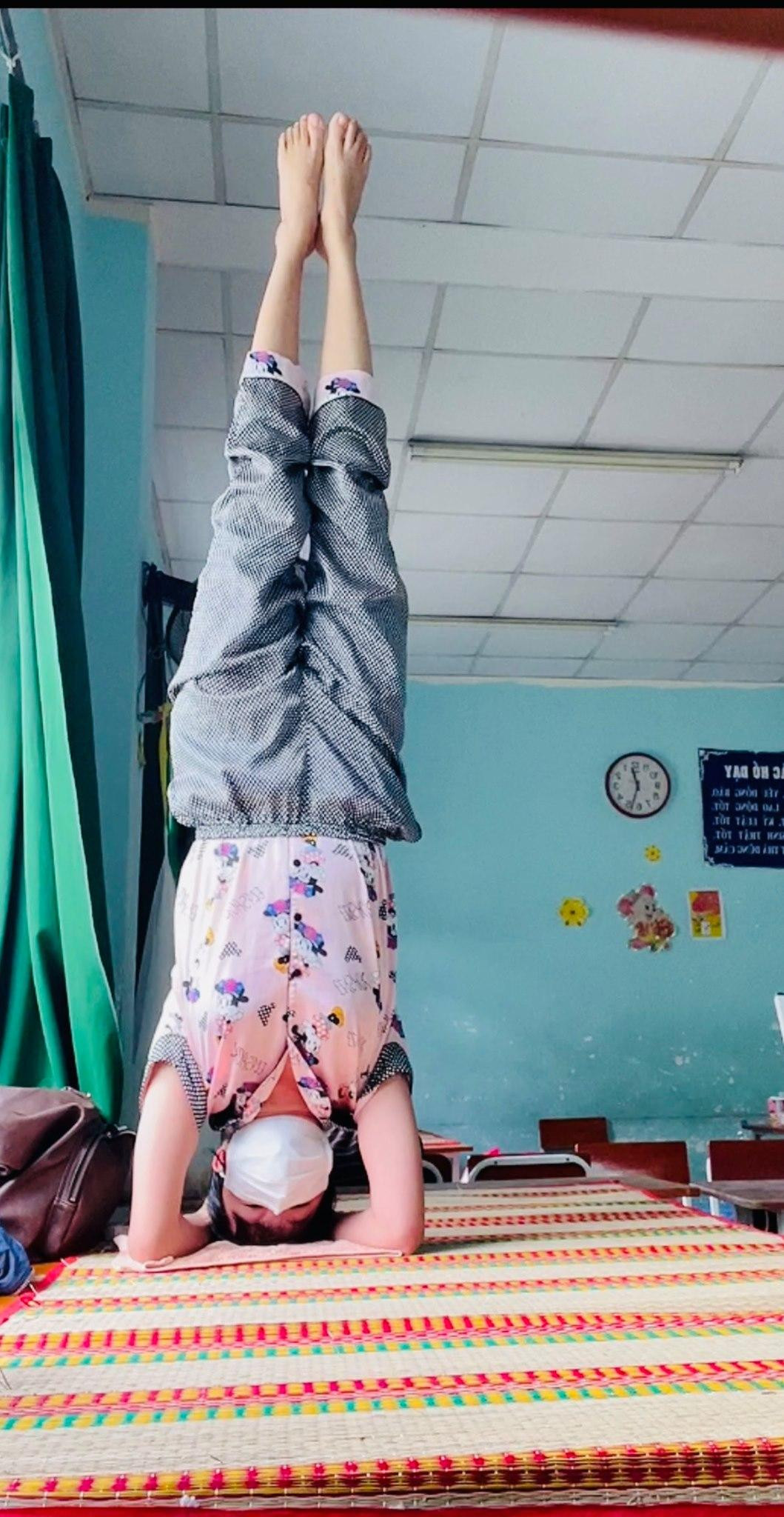 Cô Phi Yến tập yoga trên những chiếc bàn học sinh chông chênh tại khu cách ly.