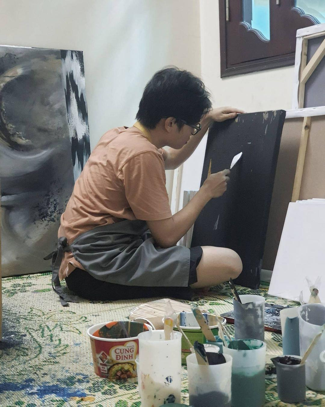 Lâm Vũ tỉ mỉ phối màu lên tranh với các họa cụ là đồ vật được tái sử dụng. Lâm Vũ tỉ mỉ phối màu lên tranh với các họa cụ là đồ vật được tái sử dụng.