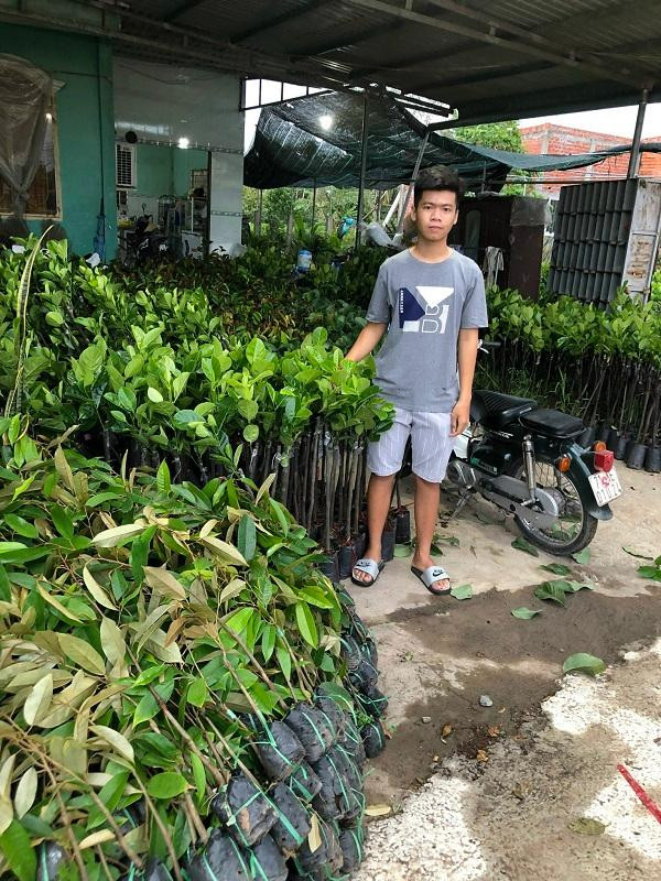 Lộc bên cửa hàng cây giống của mình.