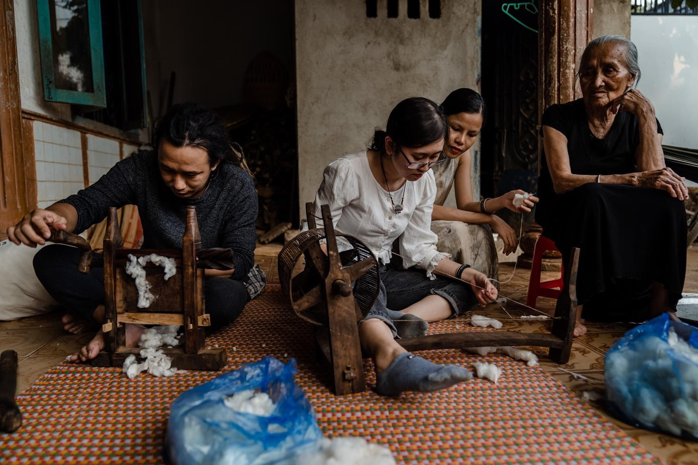 Các bạn trẻ trong nhóm cùng trải nghiệm phương pháp sản xuất thổ cẩm truyền thống do các nghệ nhân người Ê Đê chỉ dẫn.