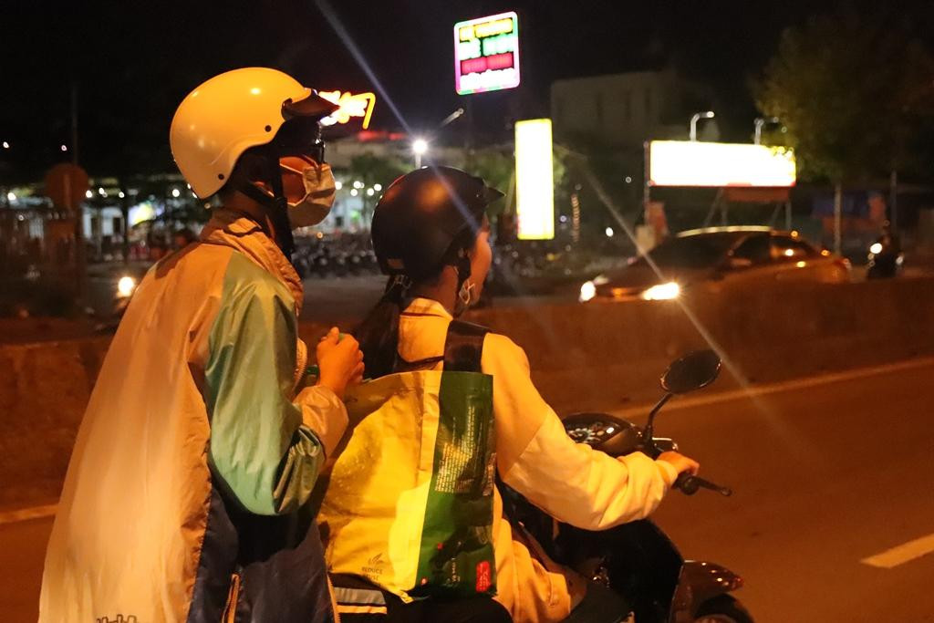 Các bạn tình nguyện viên không ngại đêm tối, đường xa đang di chuyển đến nơi phát cháo. (Ảnh: Trường Sang)