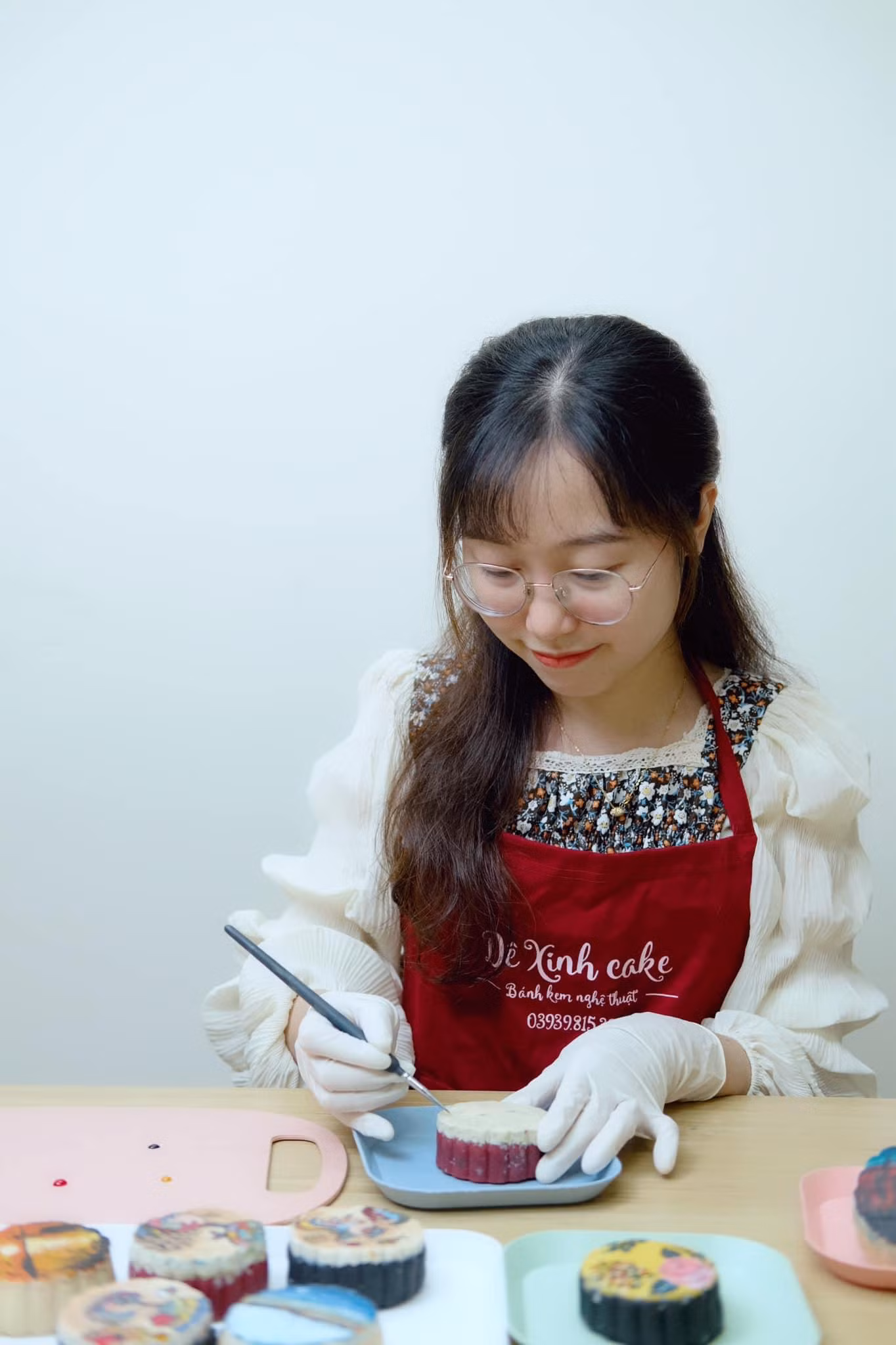 Thùy Dương tỉ mỉ vẽ tranh lên bánh. (Ảnh: NVCC)