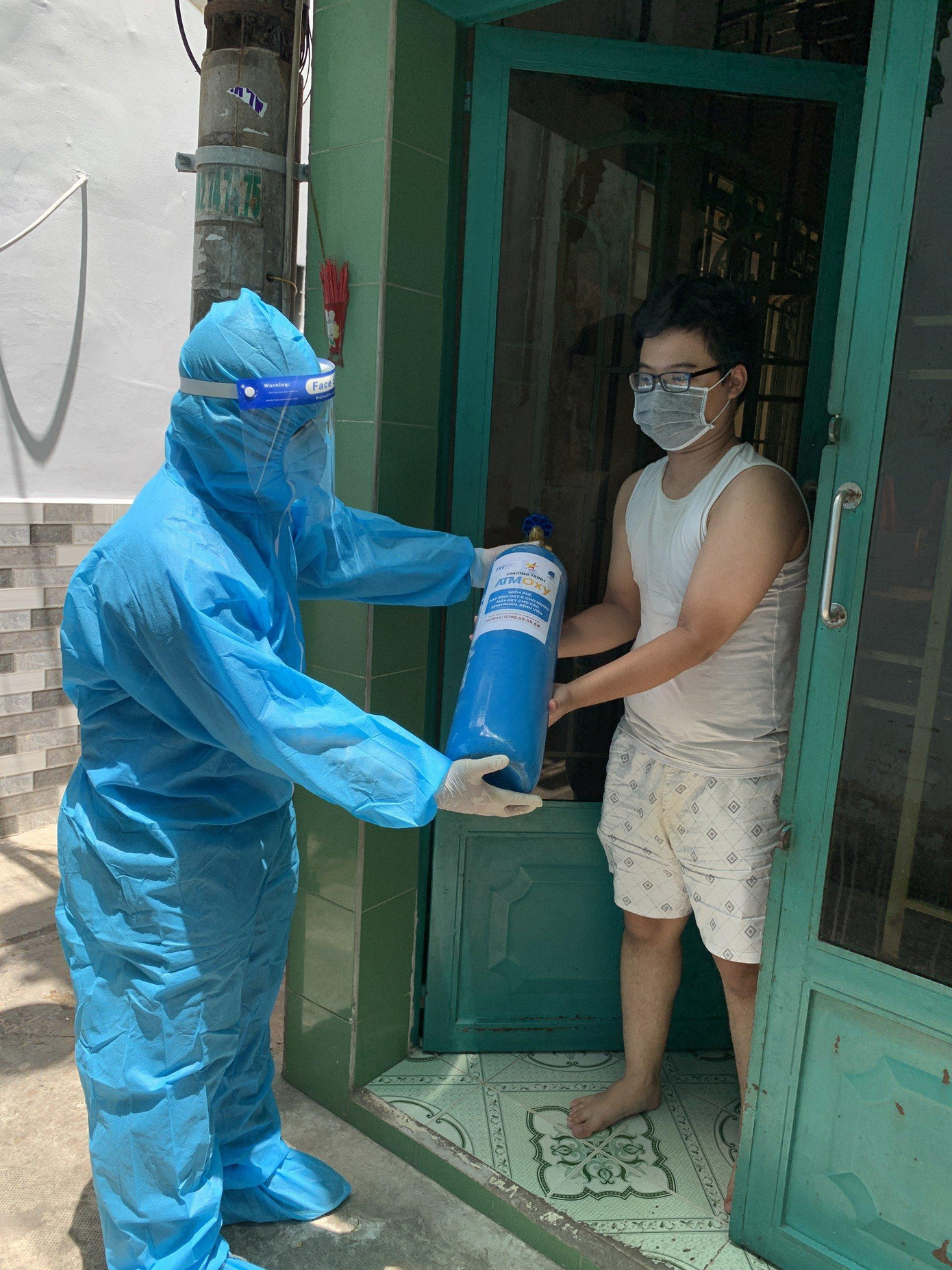 Các tình nguyện viên trao bình oxy đến tận tay người dân đang cần để điều trị COVID tại nhà.