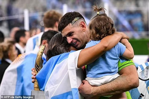 Thủ môn Emiliano Martinez của Argentina xúc động ôm vợ Amanda Mandinha và con gái Ava. Anh được trao giải Găng tay vàng FIFA. Ảnh: Getty Images.