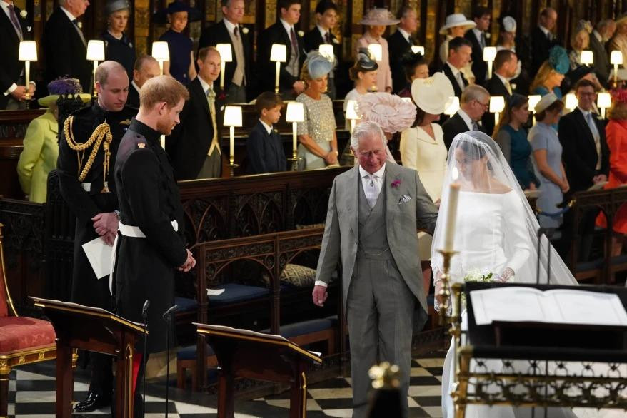 Vua Charles dẫn Meghan tiến vào lễ đường trong hôn lễ với Harry năm 2018. Ảnh: Getty Images. Vua Charles dẫn Meghan tiến vào lễ đường trong hôn lễ với Harry năm 2018. Ảnh: Getty Images.