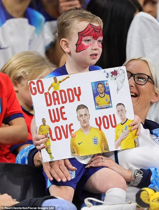 Con trai của Jordan Pickford cầm tấm biển cổ vũ tinh thần cho bố trước trận đấu. Ảnh: Forcus Images.