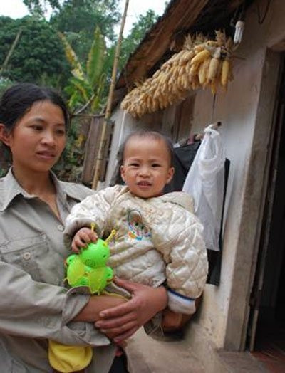 Đứa trẻ đang chơi đùa với đồ chơi nhặt được từ bãi rác