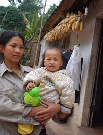 Đứa trẻ đang chơi đùa với đồ chơi nhặt được từ bãi rác
