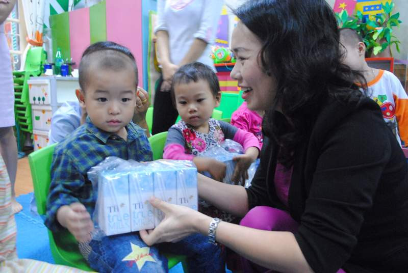 Nhiều em rụt rè, không dám lên nhận sữa, bà Thái Thị Sơn, đại diện Tập đoàn TH True Milk mang sữa tới tận chỗ ngồi của các em