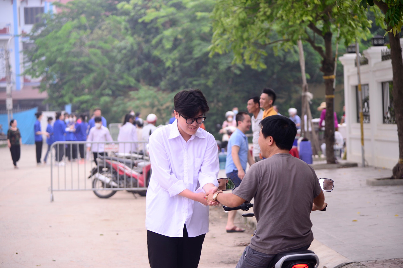 Cái bắt tay ấm áp của 2 cha con tại điểm thi trường THPT Mê Linh, huyện Mê Linh, Hà Nội. Ảnh: Như Ý Cái bắt tay ấm áp của 2 cha con tại điểm thi trường THPT Mê Linh, huyện Mê Linh, Hà Nội. Ảnh: Như Ý