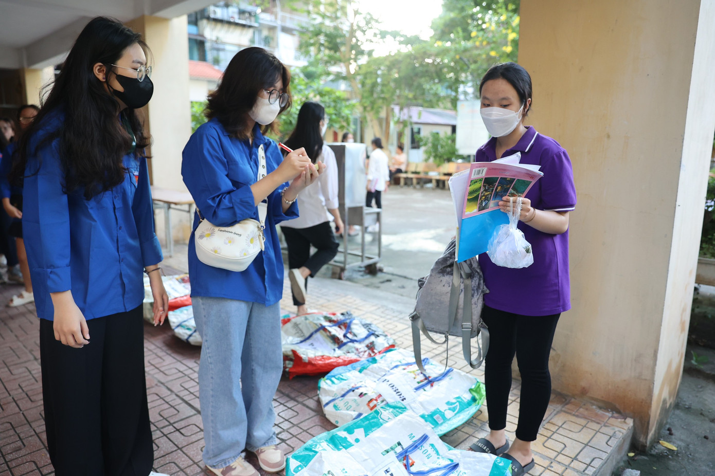 Thanh niên tình nguyện hướng dẫn, nhắc nhở thí sinh gửi hết đồ đạc, đặc biệt điện thoại ở khu vực gửi đồ. Đồ được gửi vào các túi to, sau đó thanh niên tình nguyện sẽ tập kết ở một phòng riêng biệt đảm bảo cách xa phòng thi. (Ảnh: Như Ý). Thanh niên tình nguyện hướng dẫn, nhắc nhở thí sinh gửi hết đồ đạc, đặc biệt điện thoại ở khu vực gửi đồ. Đồ được gửi vào các túi to, sau đó thanh niên tình nguyện sẽ tập kết ở một phòng riêng biệt đảm bảo cách xa phòng thi. (Ảnh: Như Ý).