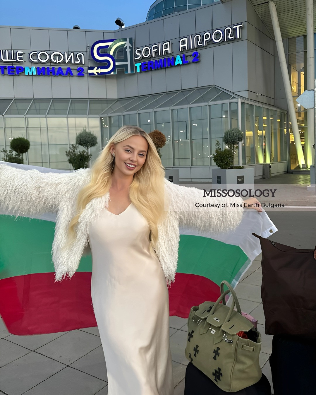 Đại diện Bulgaria - Tatiana Miroshina Savko - diện váy lụa trắng ra sân bay. Cô là người mẫu, từng xuất hiện trong các quảng cáo cho thương hiệu nổi tiếng ở quê nhà. Người đẹp 23 tuổi đang theo học chuyên ngành tâm lý học trẻ em và làm việc với một quỹ từ thiện dành cho trẻ em mồ côi.