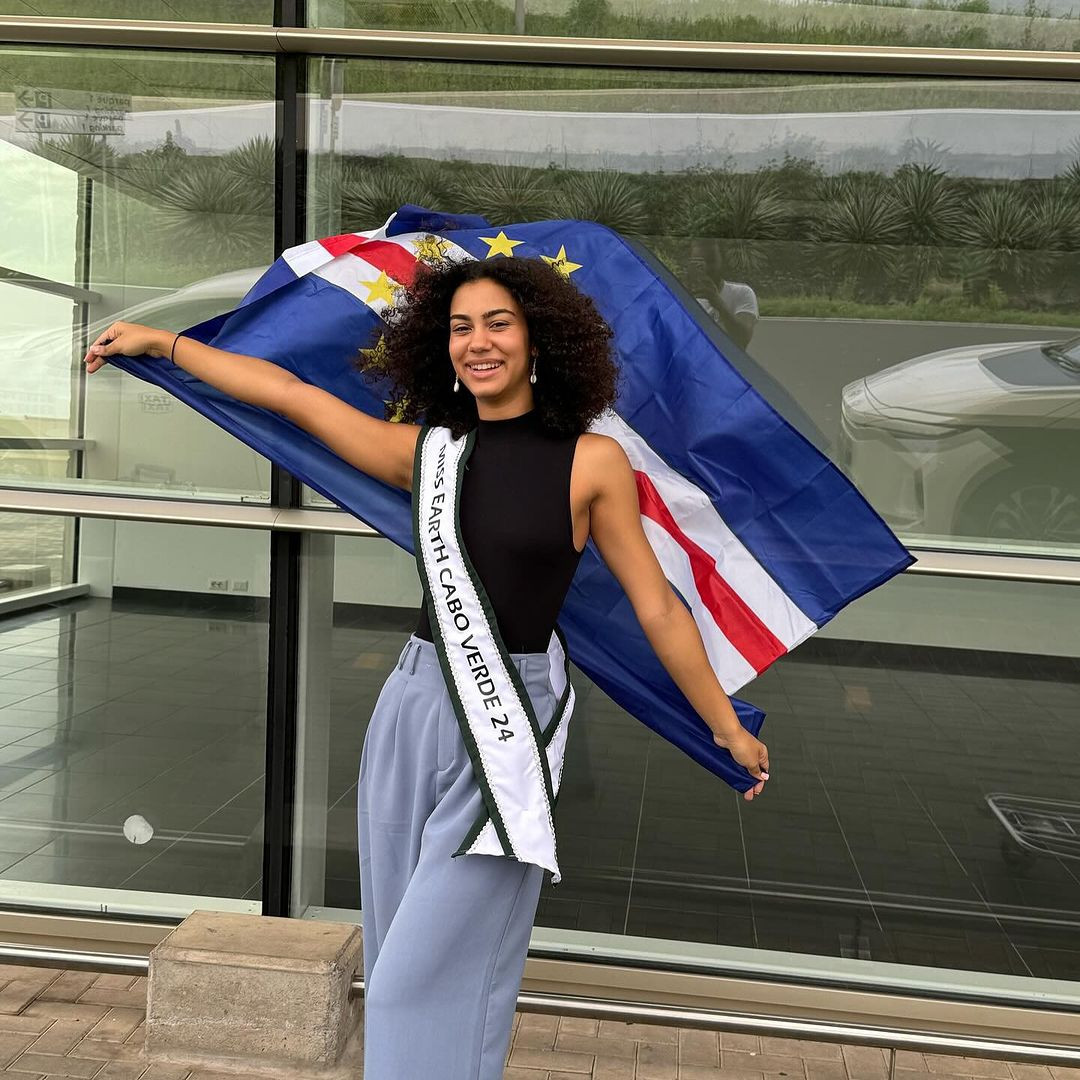 Đại diện Cabo Verde - Jasmine Jorgensen - để mặt mộc ra sân bay. Cô năm nay 19 tuổi, là sinh viên chuyên ngành kinh doanh. Thông qua công việc của mình, Jasmine hướng đến mục tiêu đề cao môi trường tự nhiên trong các chiến lược cho sức khỏe tinh thần và thúc đẩy các hoạt động bền vững.