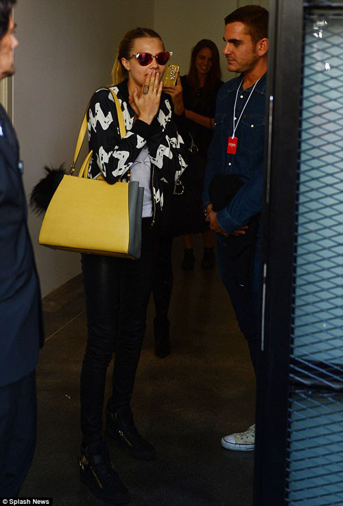 Cara Delevingne dùng chiếc túi màu vàng nổi bật làm điểm nhấn cho cả set đồ khá đơn giản. Siêu mẫu 9X trung thành với phong cách năng động, unisex như thường lệ